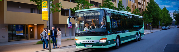 Buslinie 360 h&auml;lt an Haltestelle mit wartenden Fahrg&auml;sten